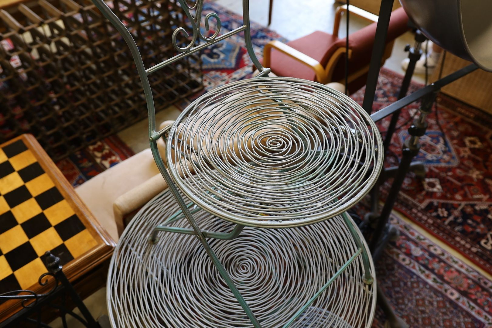 A painted wrought iron and wirework circular garden table, diameter 70cm, height 74m and two chairs